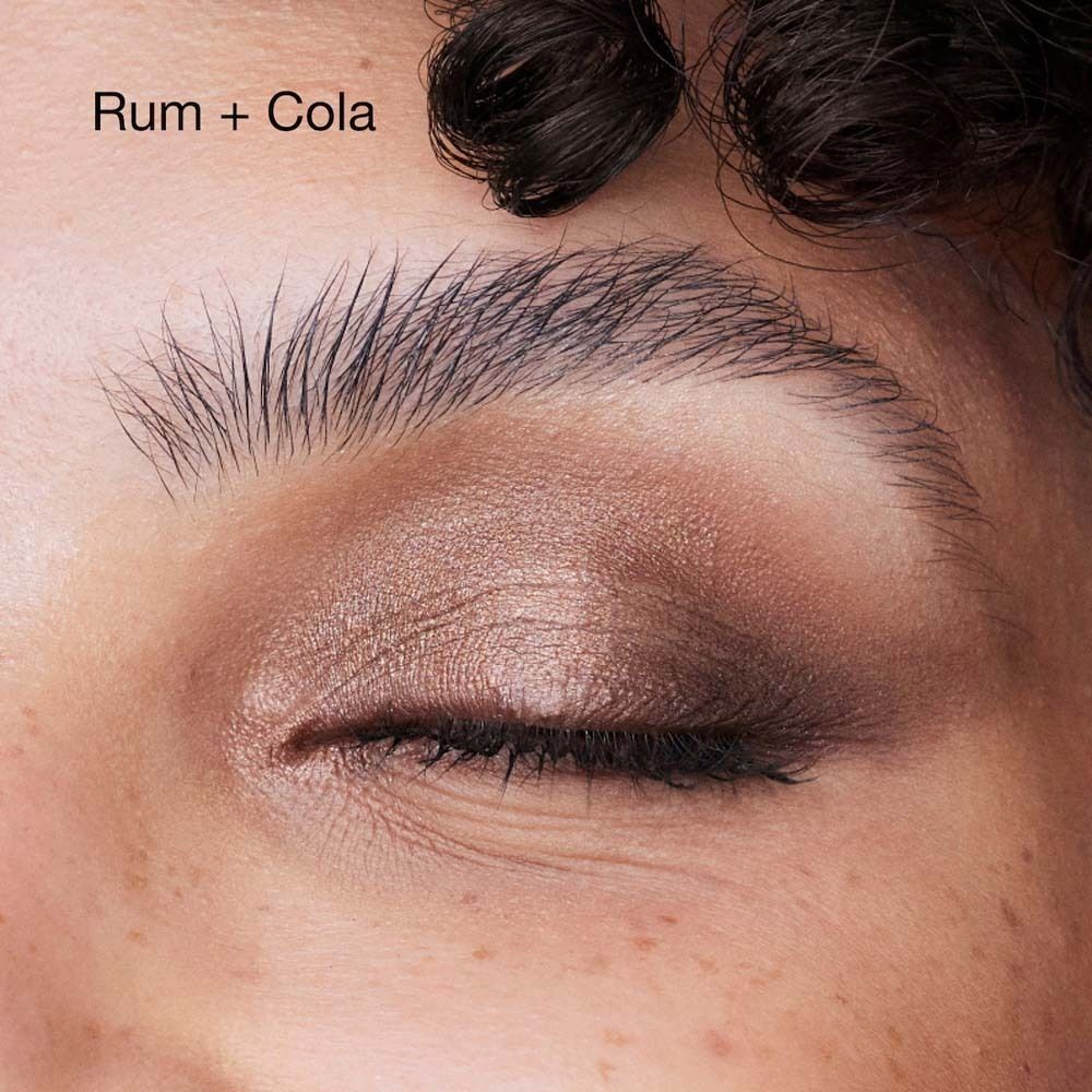 Augen-Make-up in Braun- und Rottönen, mit Text "Rum + Cola".