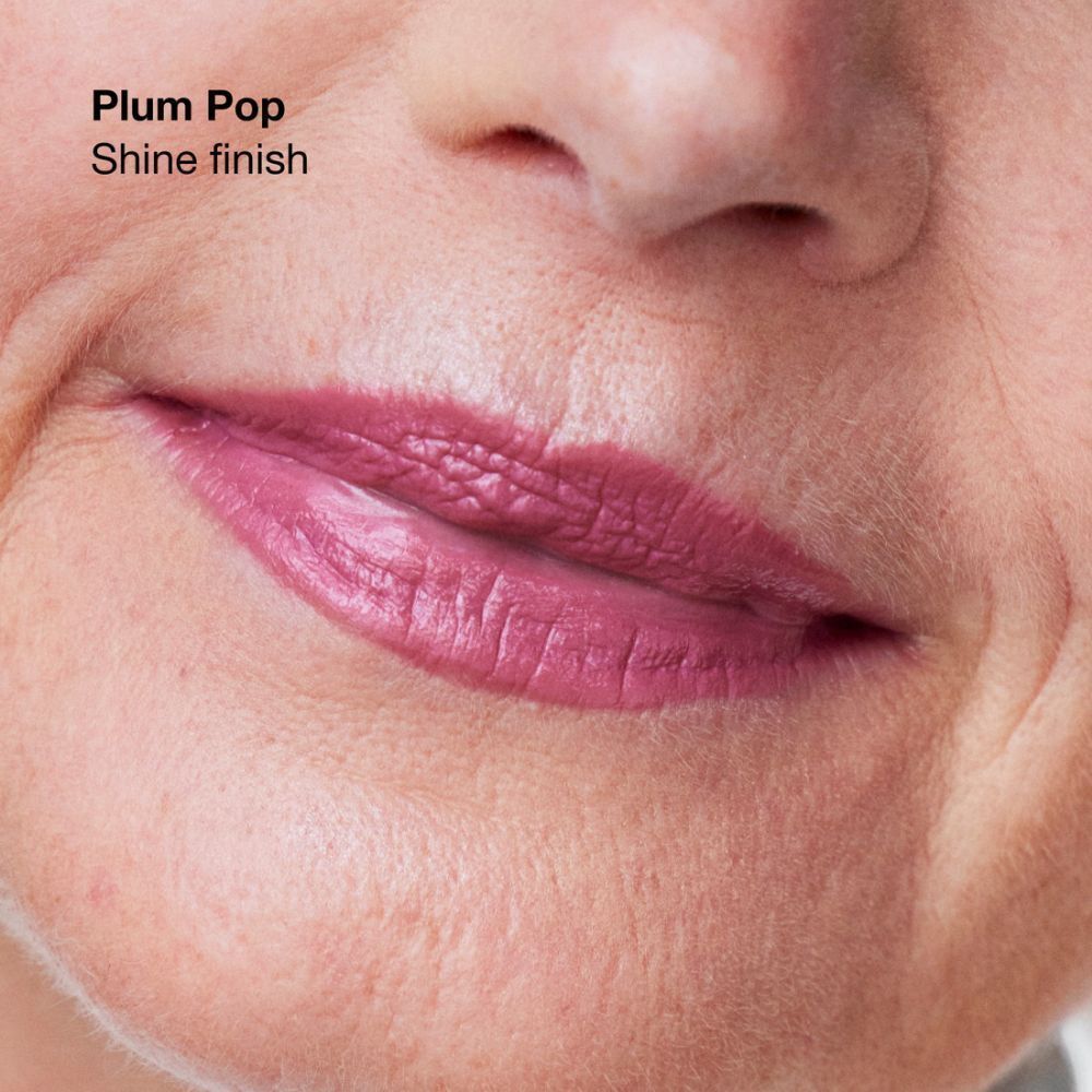 Nahaufnahme eines Mundes, der den Clinique Pop Lippenstift Soft Plum Pop mit glänzendem Finish trägt.