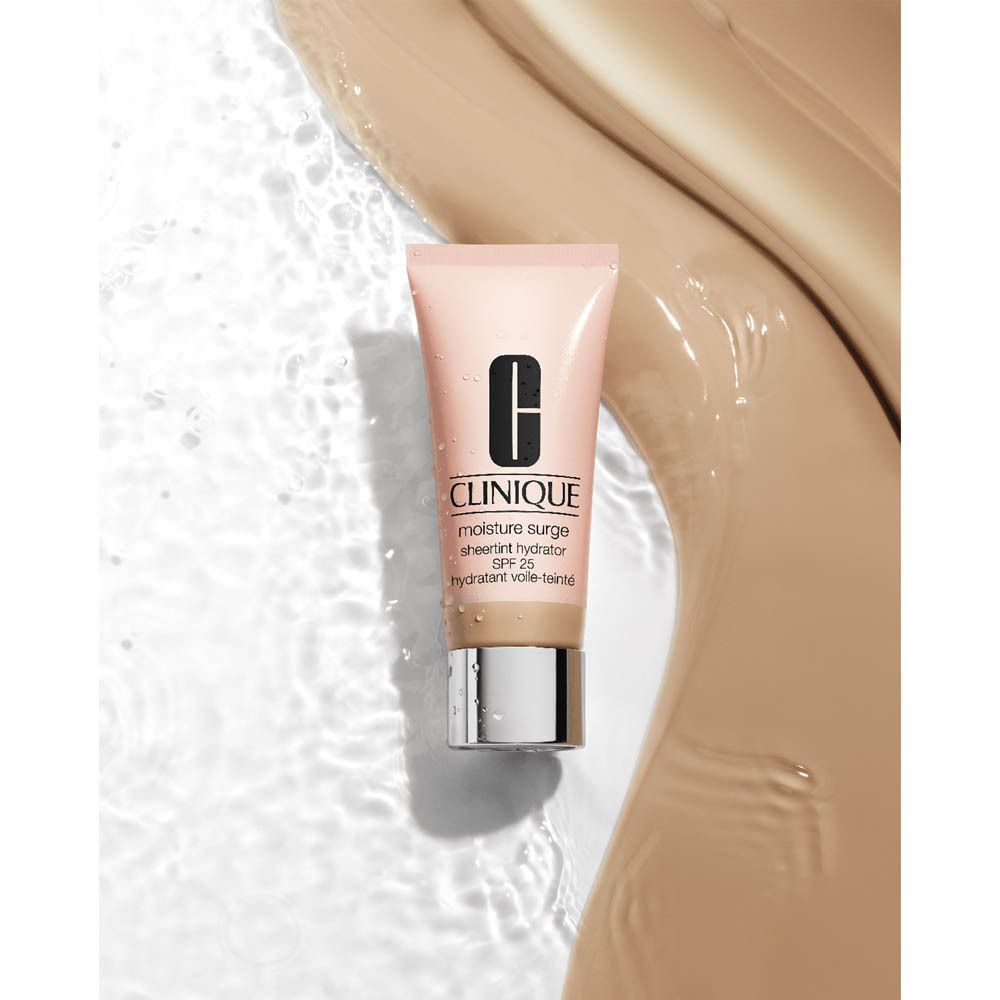 Clinique Moisture Surge Sheer Hydrator in einer rosa Tube mit silbernem Deckel, umgeben von Wasser und Make-up-Schichten.