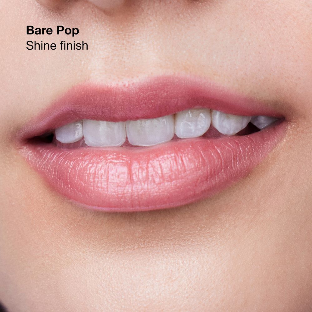 Lippenmodell trägt Clinique Pop Lippenstift in Soft Bare Pop mit schimmerndem Finish.