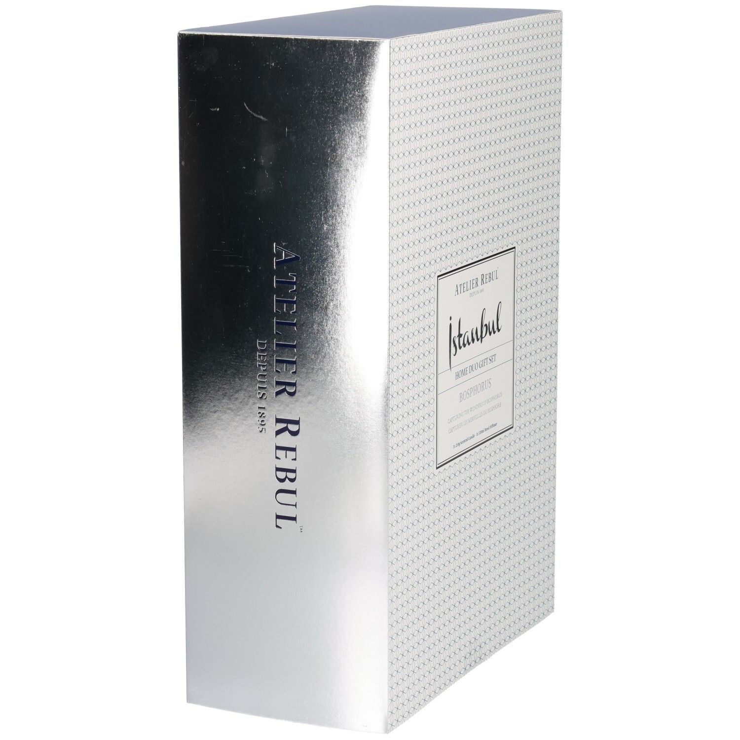 Seitenansicht einer Geschenkbox mit silberner Metallic-Oberfläche und vertikalem Atelier Rebul Schriftzug.