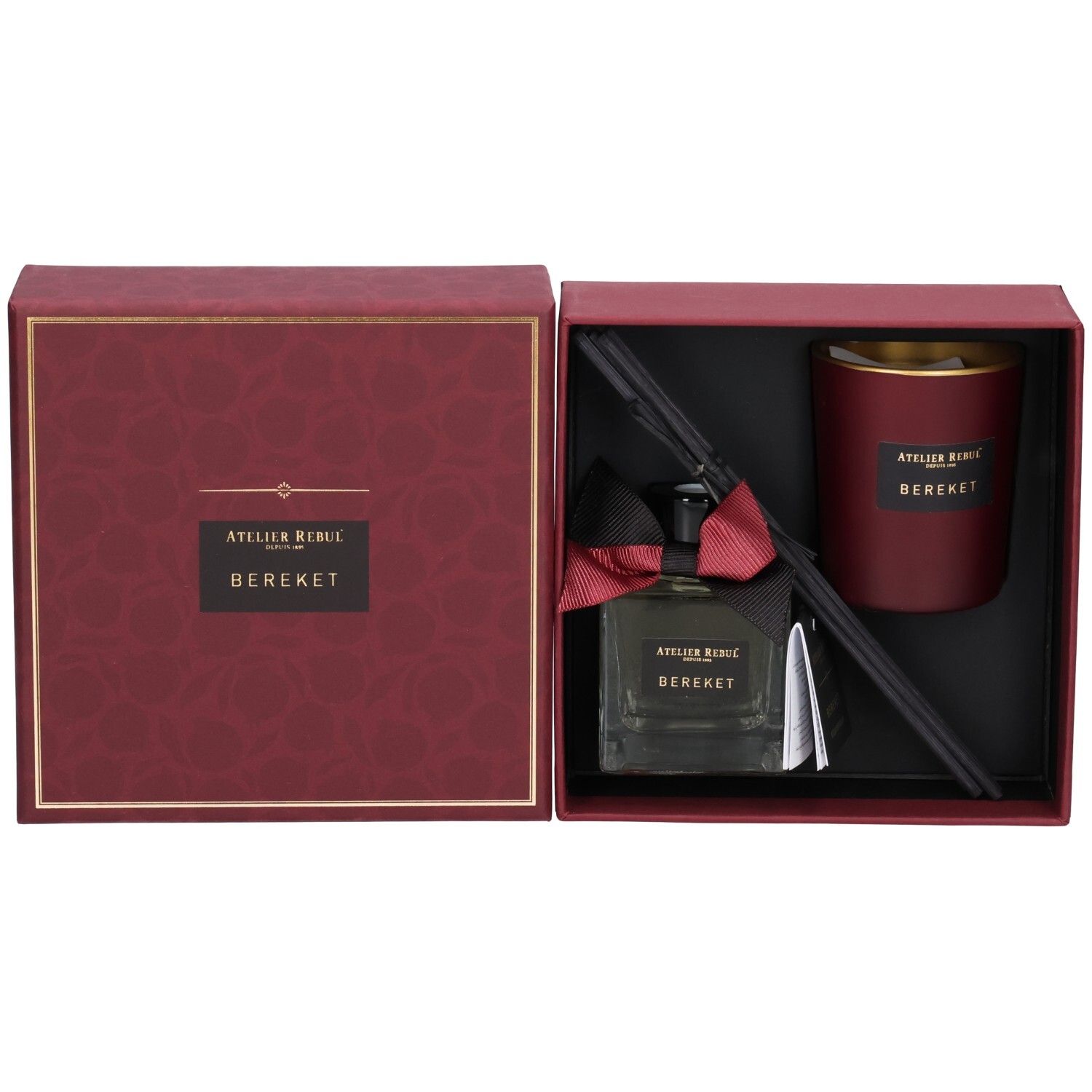 Geöffnete Geschenkbox mit Duftflasche, Kerze und Diffusor-Stäbchen. Rote und schwarze Elemente.