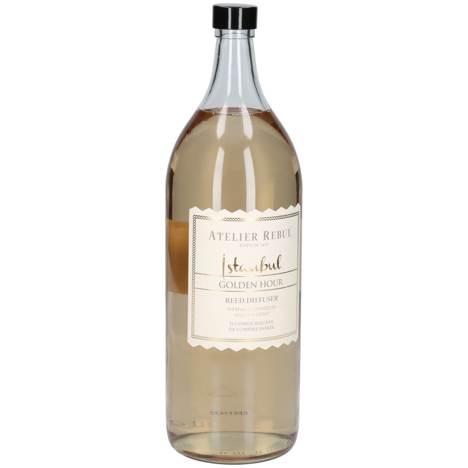 Große, transparente Glasflasche mit schwarzem Deckel. Etikett mit goldfarbenem Schriftzug: Atelier Rebul Istanbul Golden Hour Reed Diffuser.