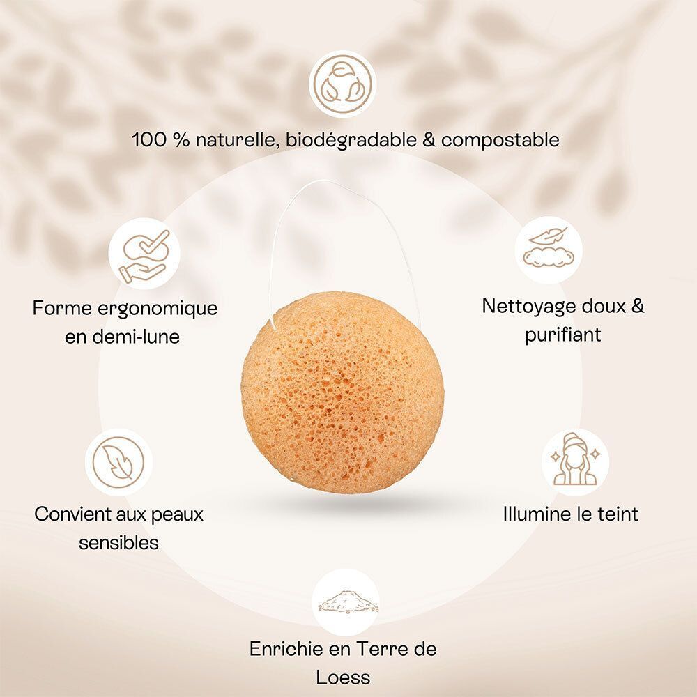 Mains tenant une éponge konjac ronde et orange sous l'eau courante.