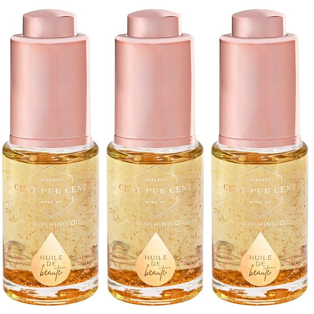Trois flacons d'huile de beauté avec particules dorées et bouchons roses.