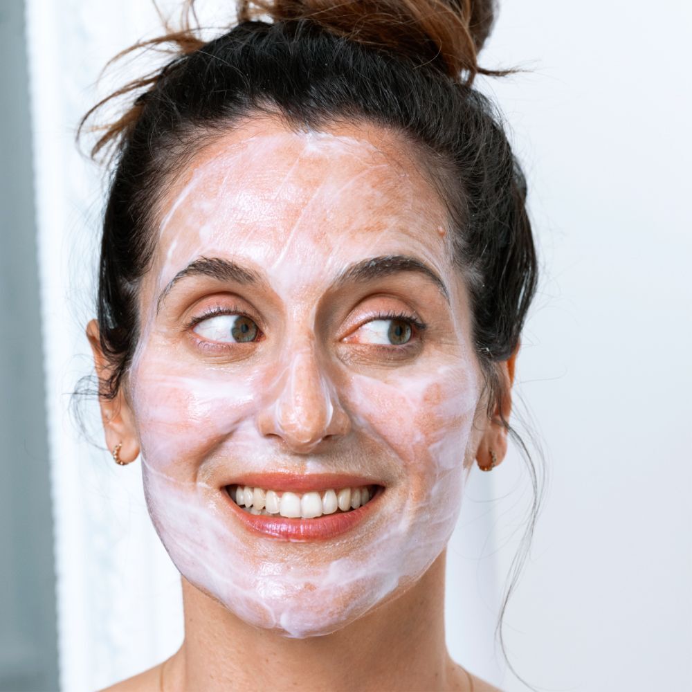 Frau mit CLAIRIAL Night Peel als Maske im Gesicht.
