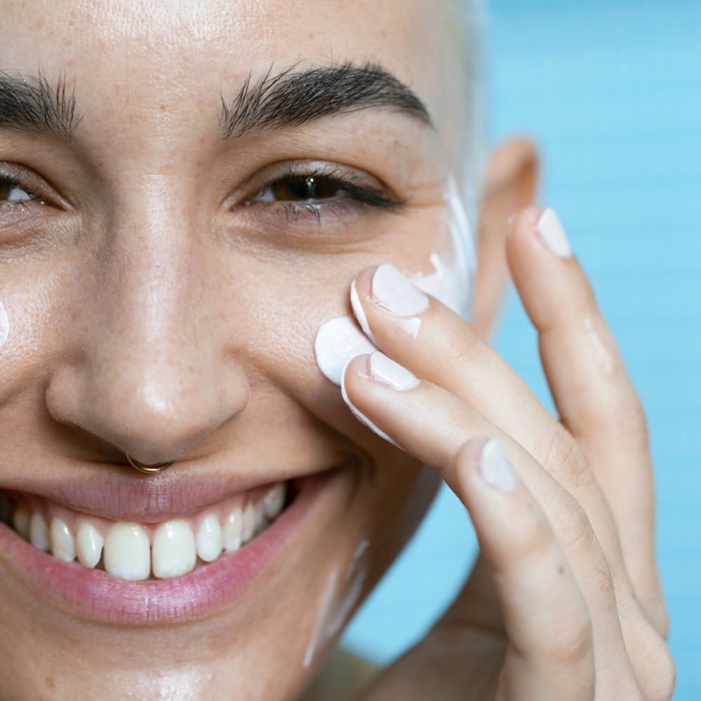 Une femme applique le SVR Sensifine Nutri-Baume sur son visage.