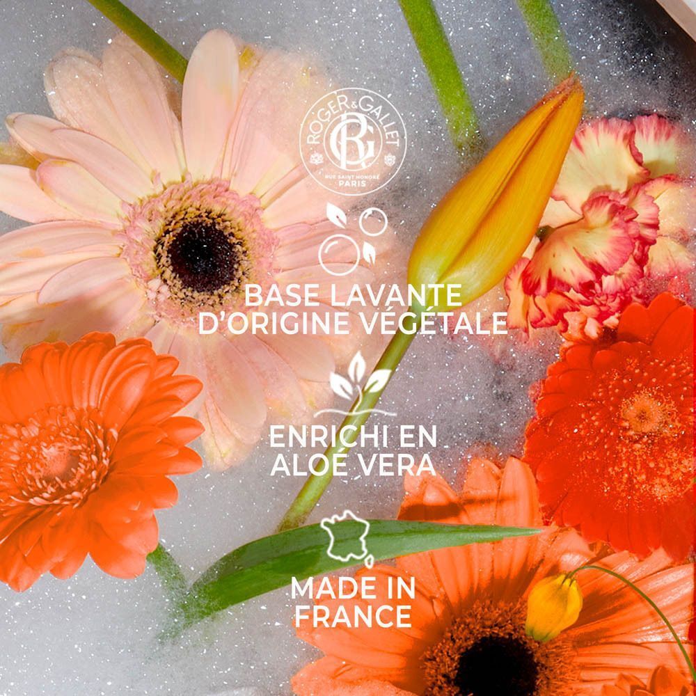 Gros plan sur le gel douche Roger & Gallet NÉROLI avec des fleurs.