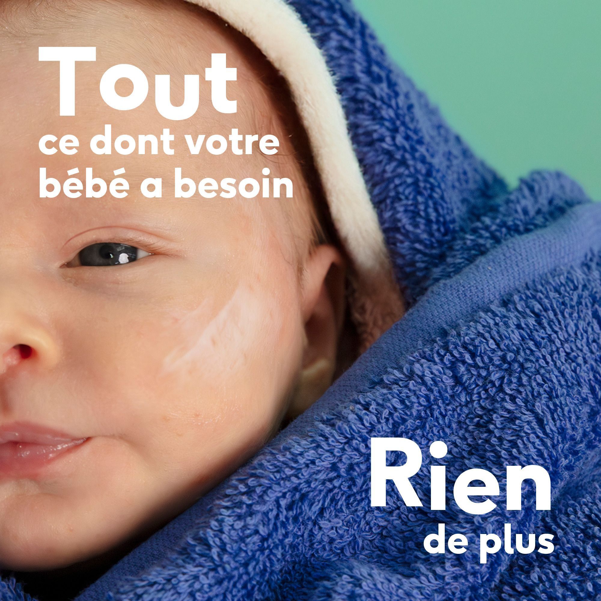 Gros plan d'un bébé enveloppé dans une serviette bleue.