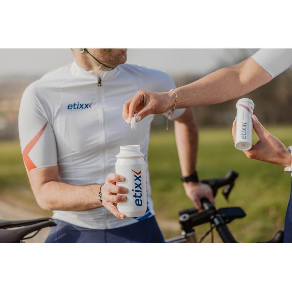 Sportler mischt Etixx Isotonic Drink Tabs Zitrone in eine Trinkflasche. Etixx-Trinkflasche sichtbar.