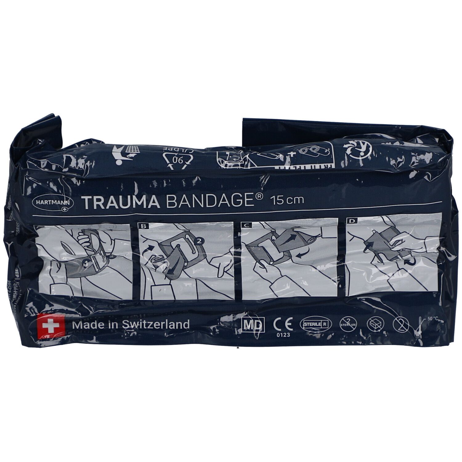 Dunkelblaue Verpackung. Aufdruck: HARTMANN TRAUMA BANDAGE 15 cm. Illustrationen zur Anwendung. Schweizer Kreuz. Made in Switzerland.