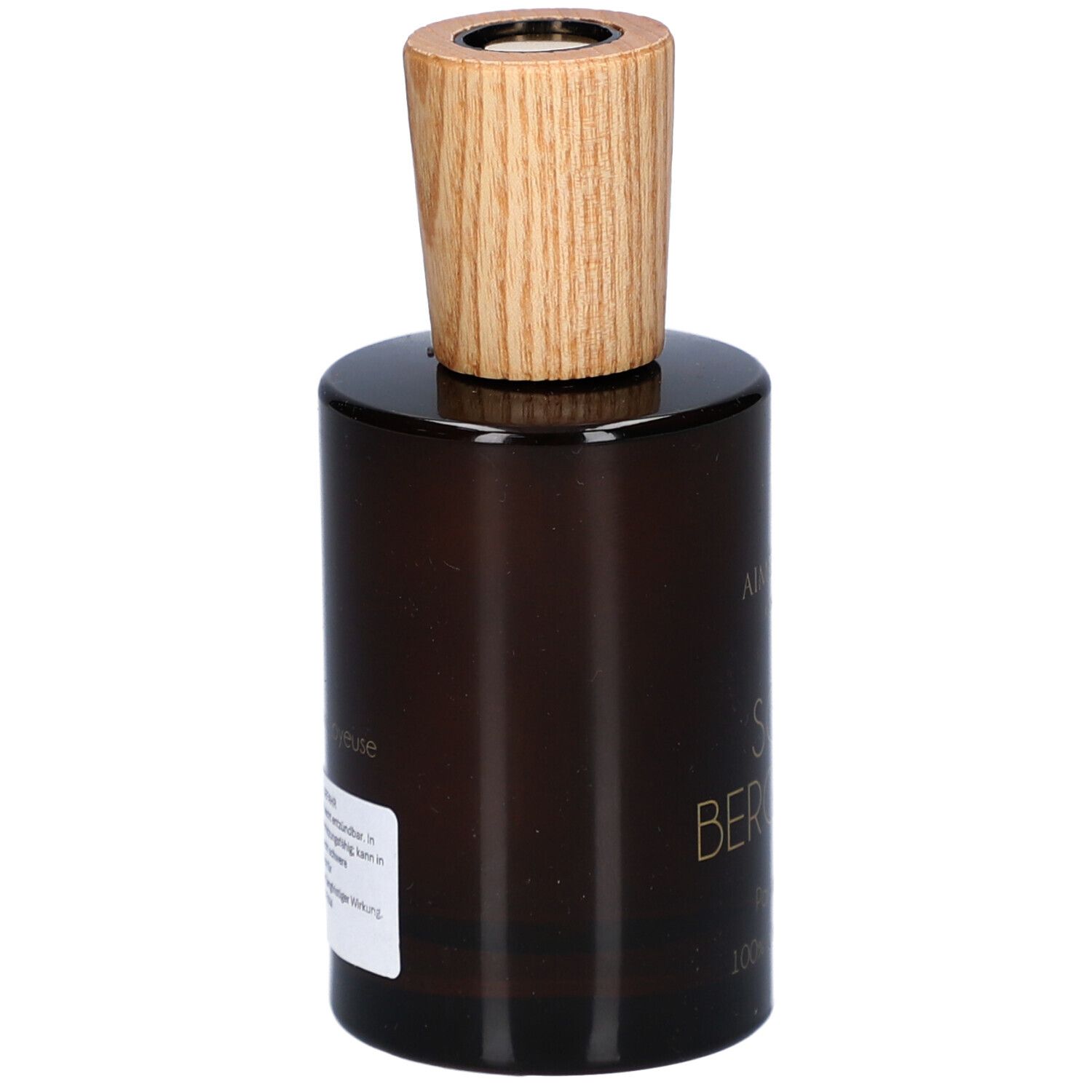 Flacon en verre brun avec bouchon en bois. Étiquette au dos avec texte. Nom du produit illisible.