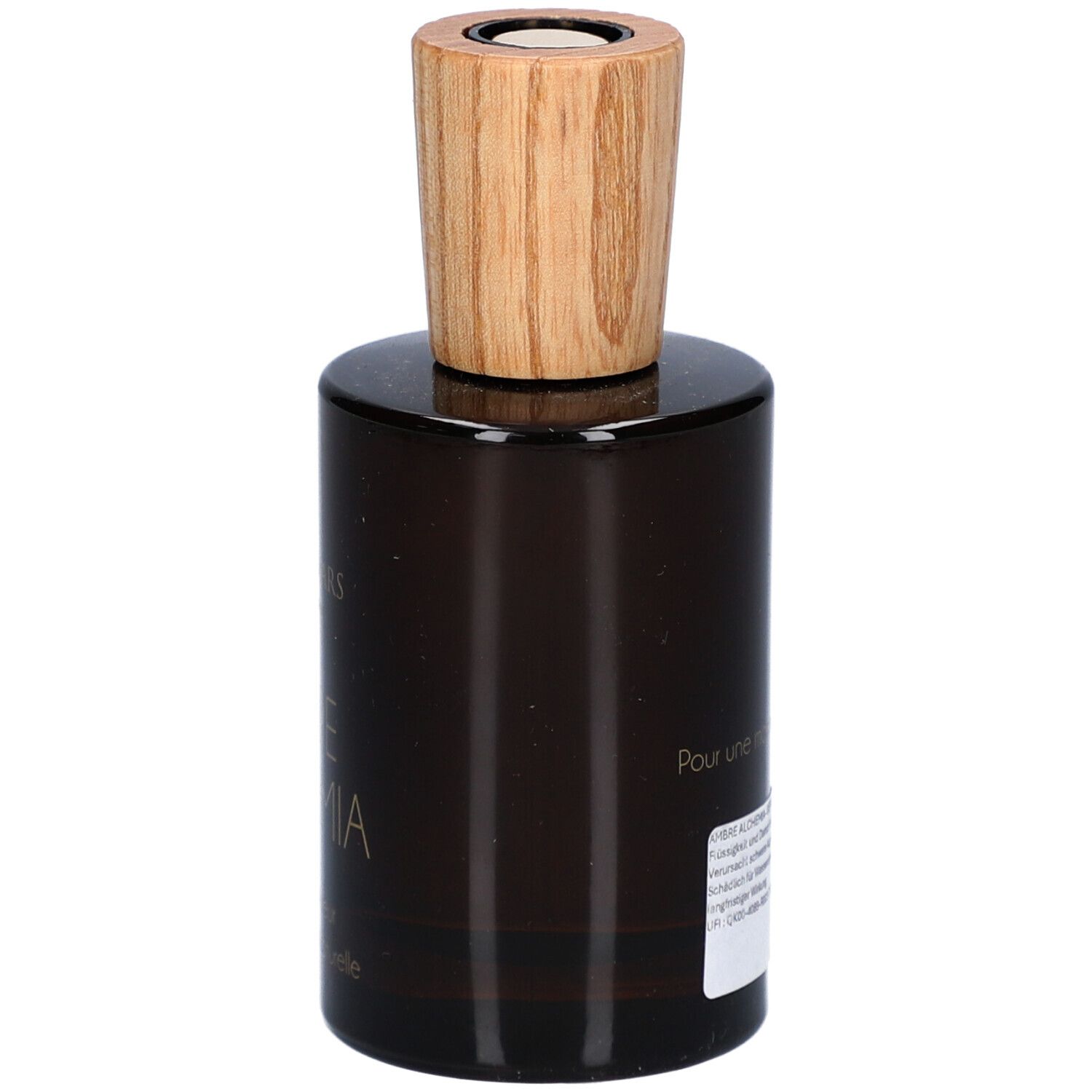 Flacon en verre brun avec bouchon en bois. Inscription: AMBRE ALCHEMIA. Étiquette avec texte. Marque: Aimée de Mars.