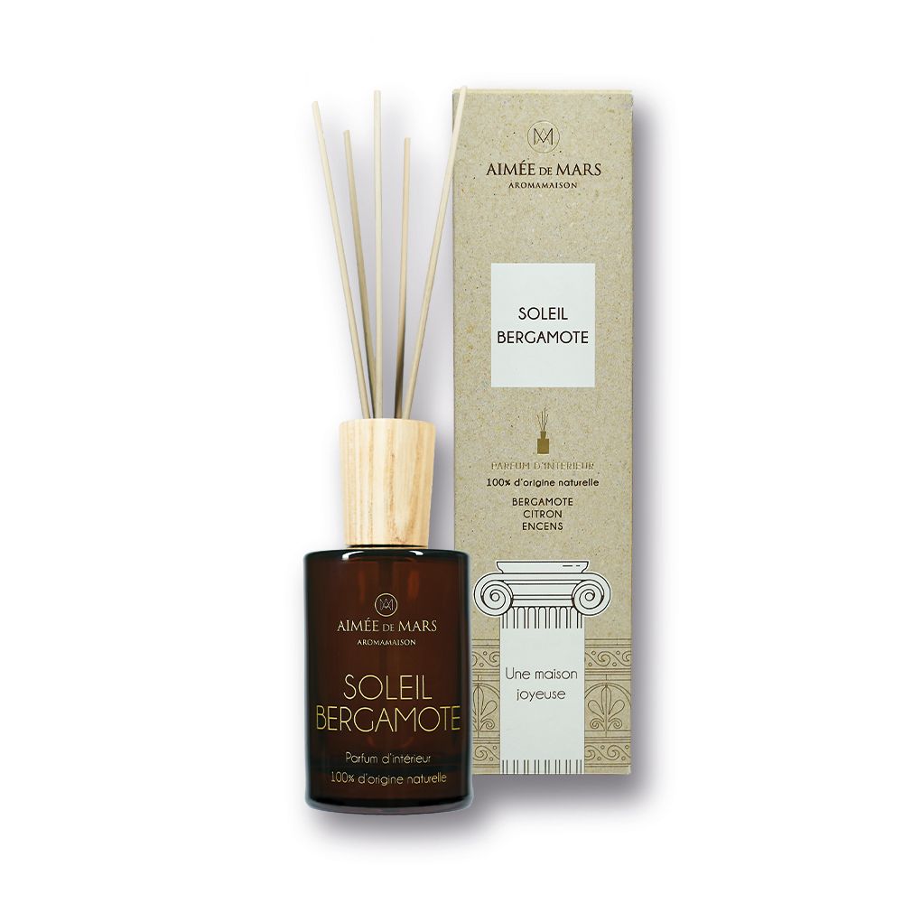 Braune Glasflasche mit Holzverschluss und Stäbchen. Daneben eine längliche Pappschachtel. Aufschrift: Soleil Bergamote.