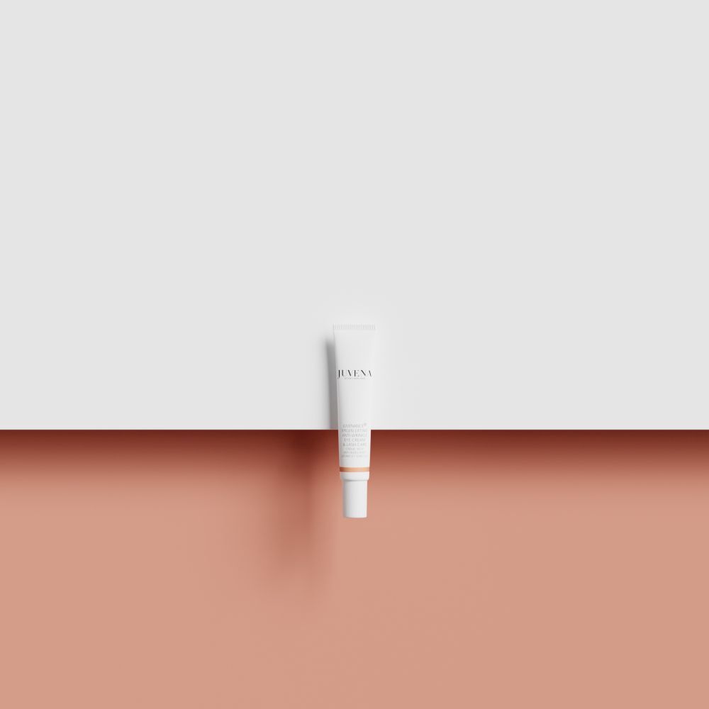 Tube blanc sur fond rose et blanc. Nom du produit et marque non visibles.