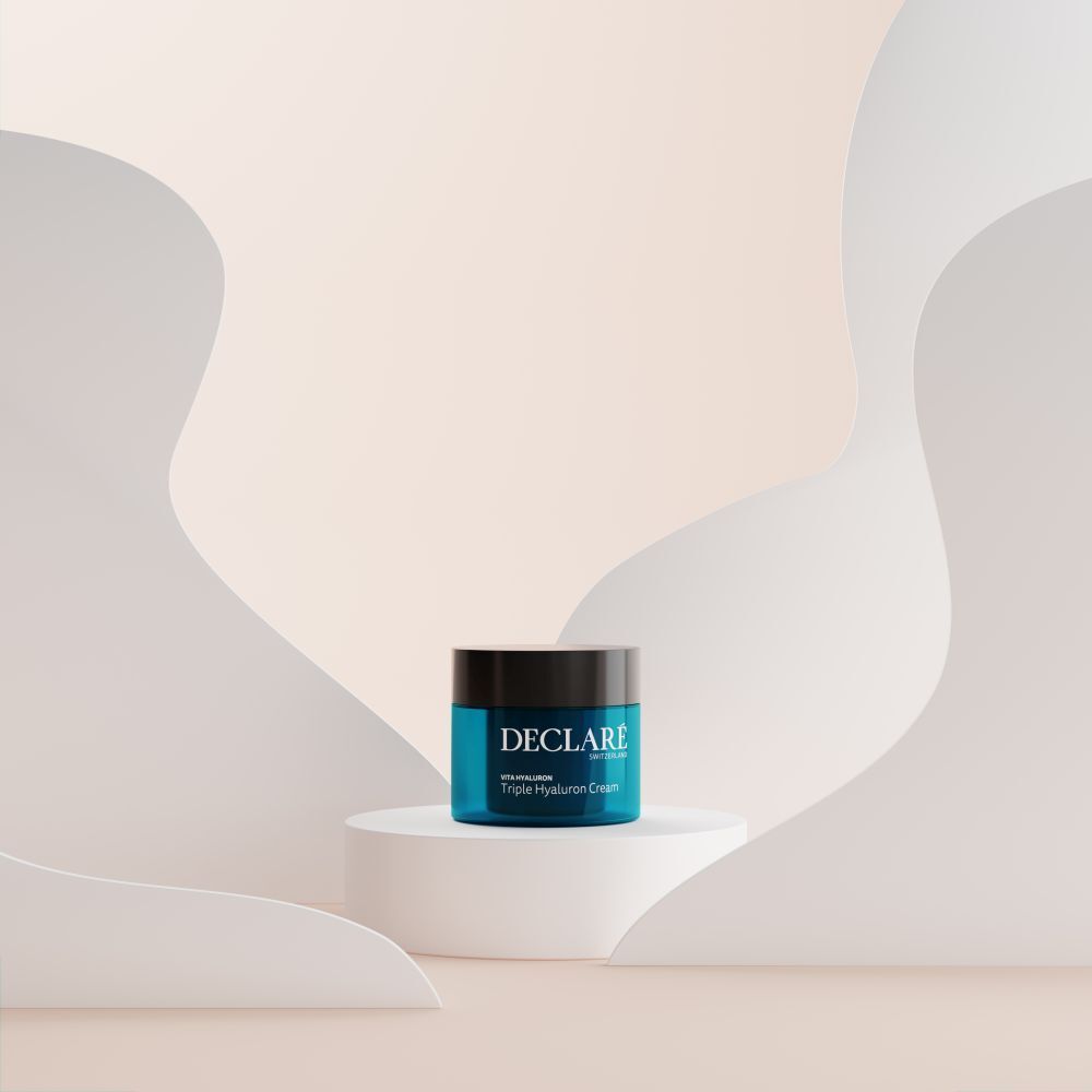 Pot de crème sur socle. Fond avec formes blanches. Inscription : DECLARÉ, Vita Hyaluron Triple Hyaluron Cream.