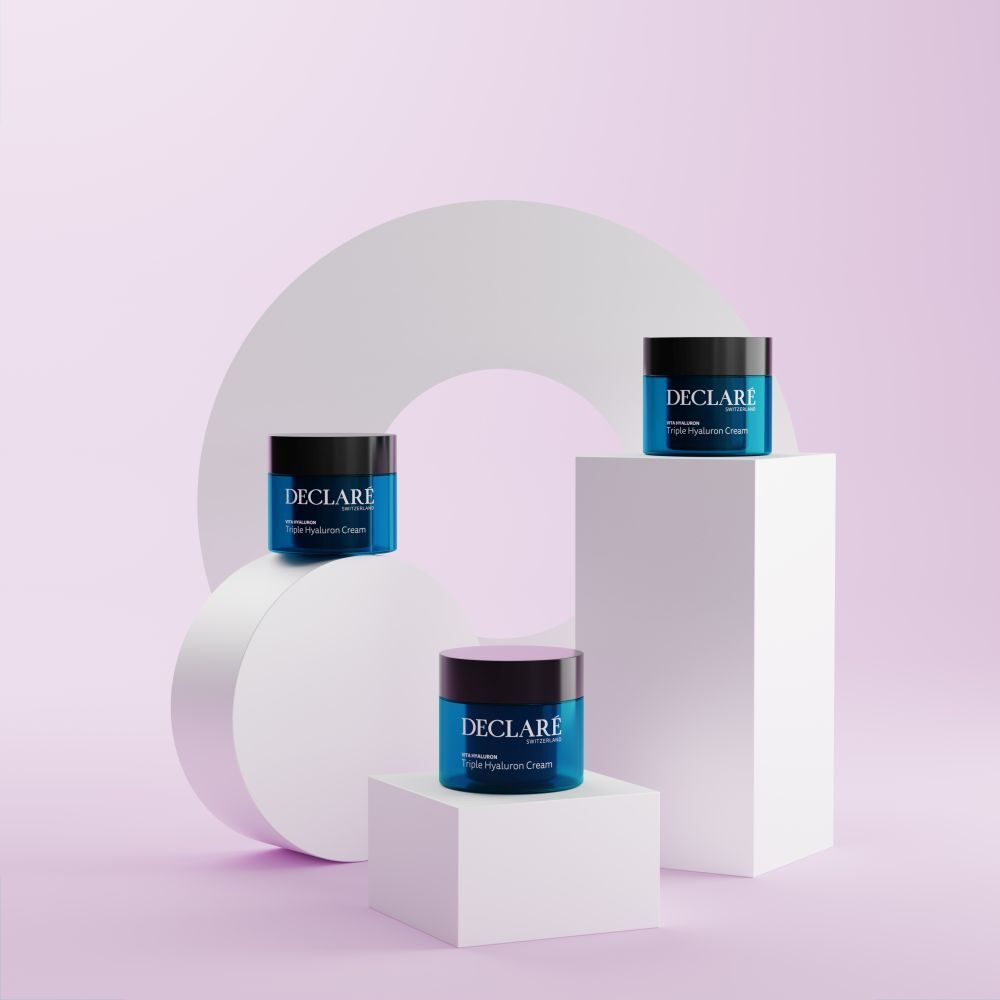 Trois pots de crème sur socles. Inscription : DECLARÉ, Vita Hyaluron Triple Hyaluron Cream. Fond : formes géométriques.