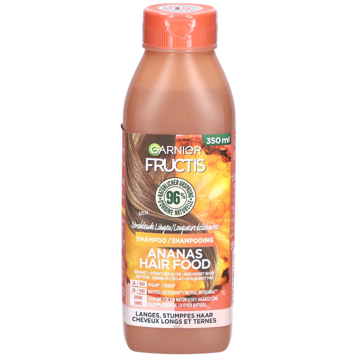 Flasche Garnier Fructis Hair Food Ananas-Glanzshampoo. Orangefarbener Deckel, braune Flüssigkeit. Etikett mit Produktinformationen.