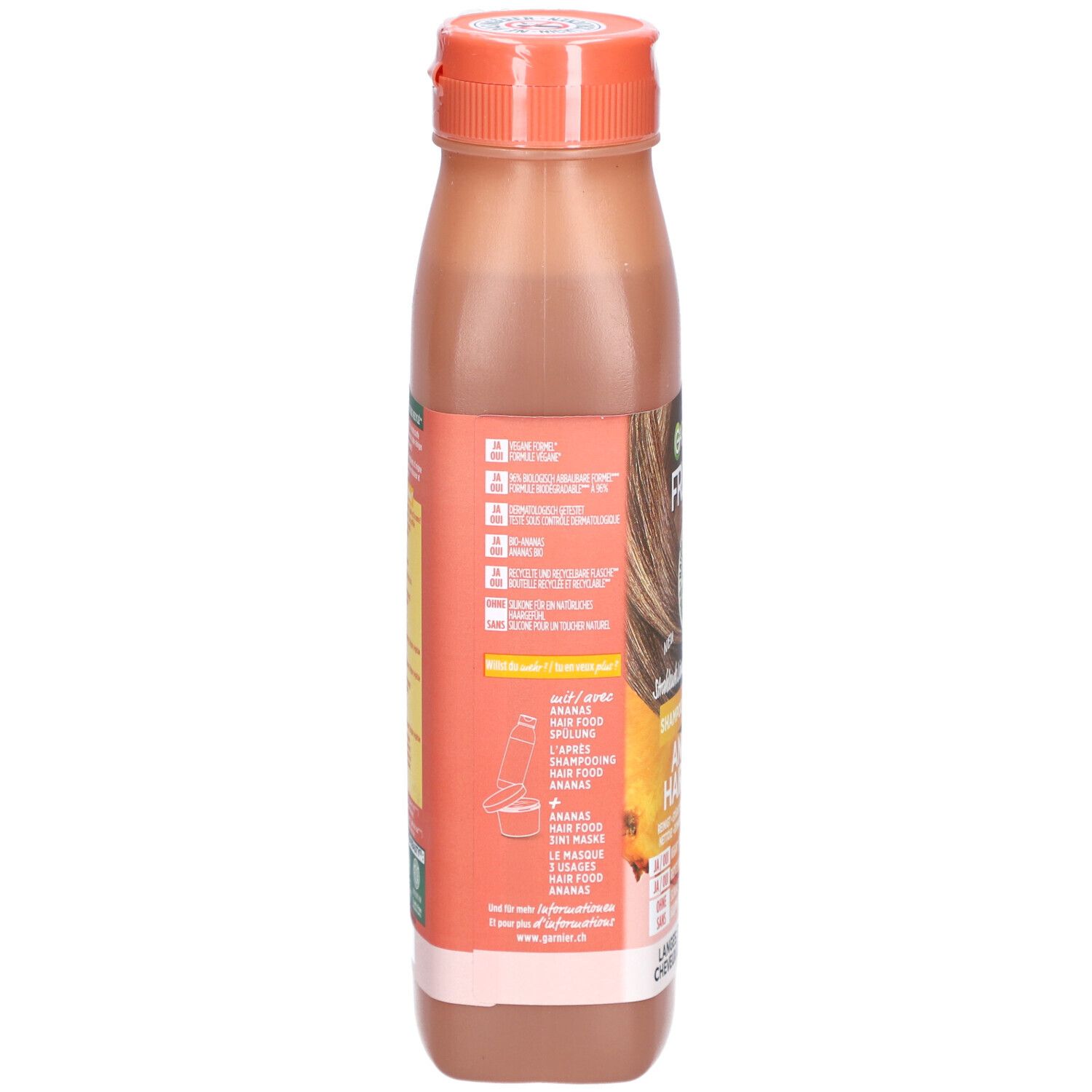 Rückseite der Shampoo-Flasche. Etikett mit Inhaltsstoffen, Anwendungshinweisen und Herstellerinformationen. Orangefarbener Deckel.