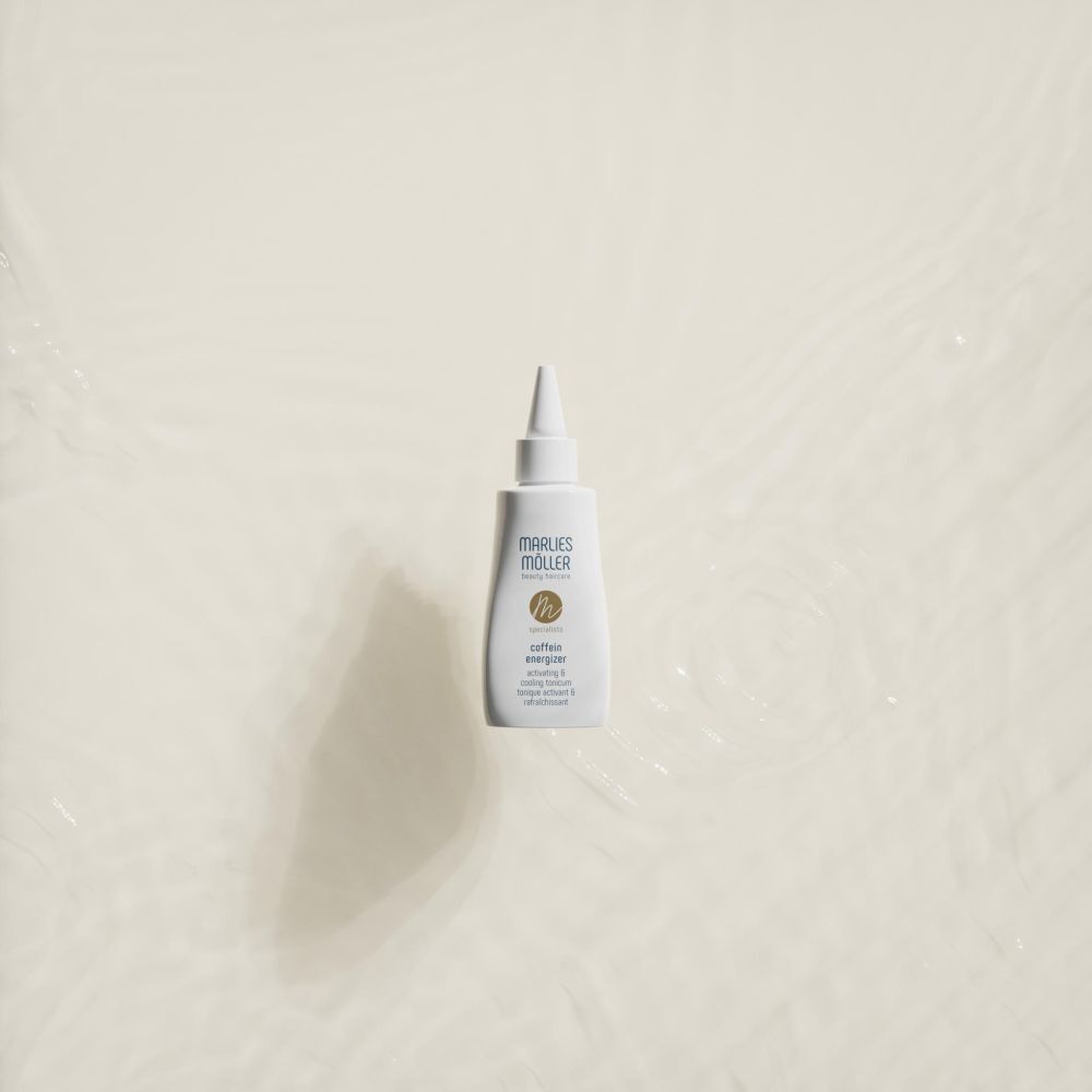 Weiße Flasche mit spitzem Applikator im Wasser. Aufschrift: Marlies Möller, Coffein Energizer.