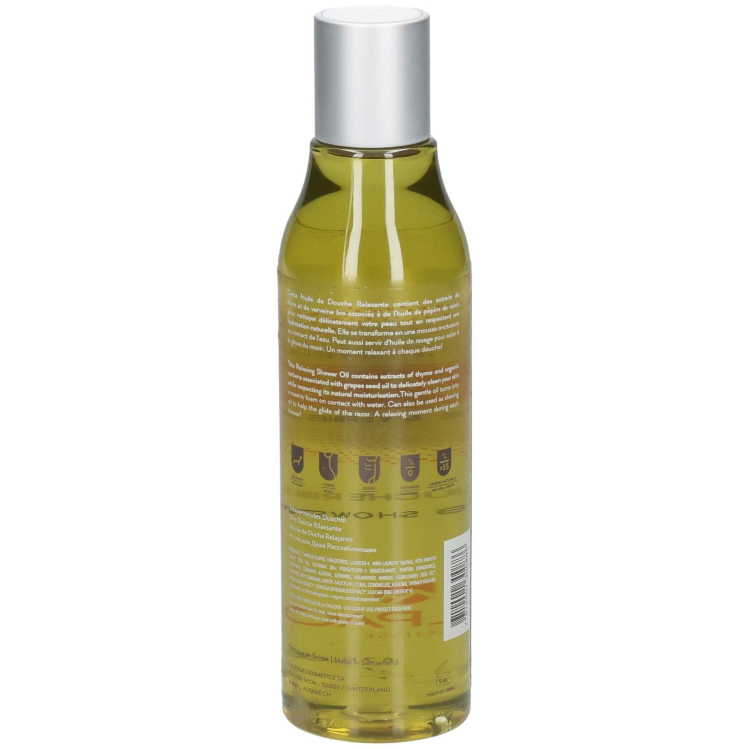 Rückseite der Körperpflegeölflasche. Transparente Flasche mit silbernem Deckel. Text und Logos auf dem Etikett.