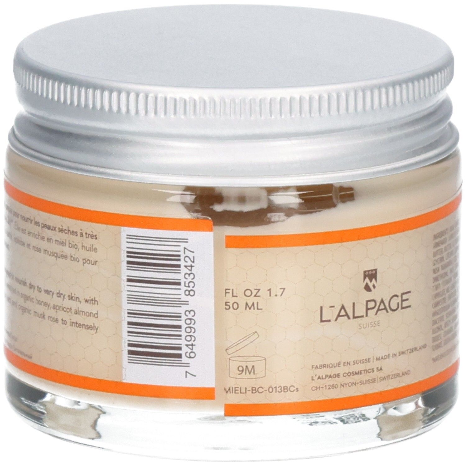 Pot en verre avec couvercle argenté. Étiquette avec texte, code-barres et logo. Bord orange. 50 ml.