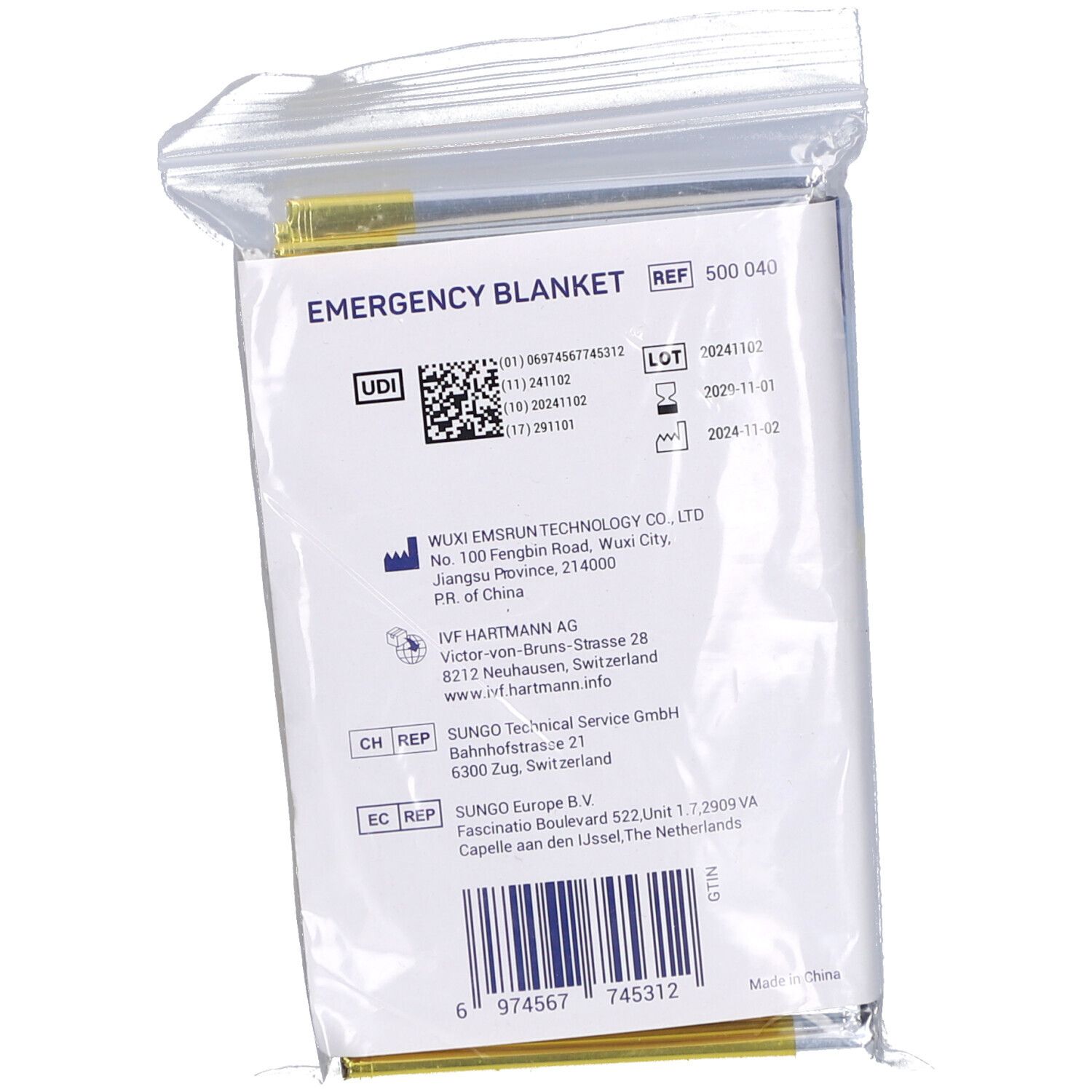 Rückseite der Notfalldecke in Folienverpackung. Text: EMERGENCY BLANKET, REF 500 040. Mit Barcode und UDI-Code.