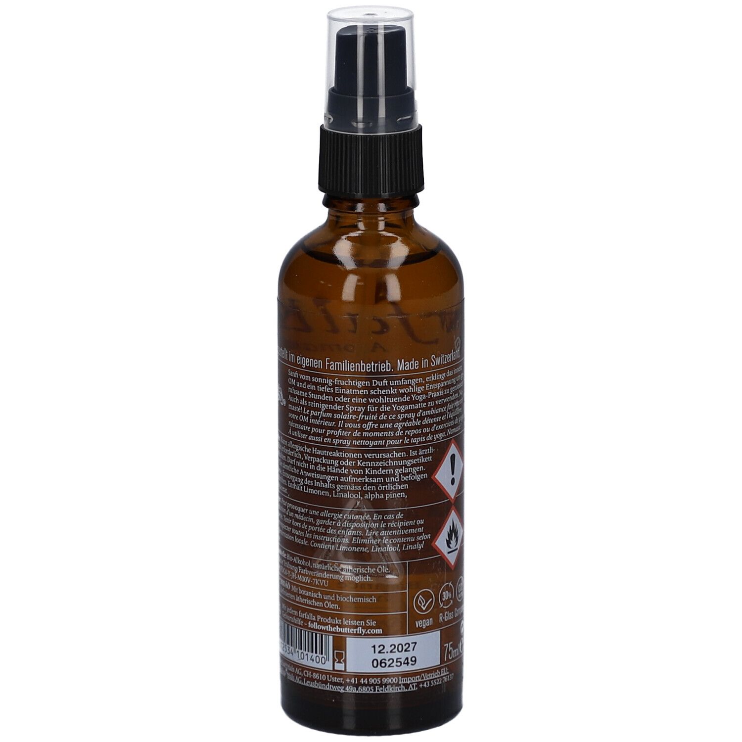 Braune Glasflasche mit Zerstäuber. Rückseite mit Text, Gefahrensymbolen und Chargennummer. Aufschrift: 75ml.