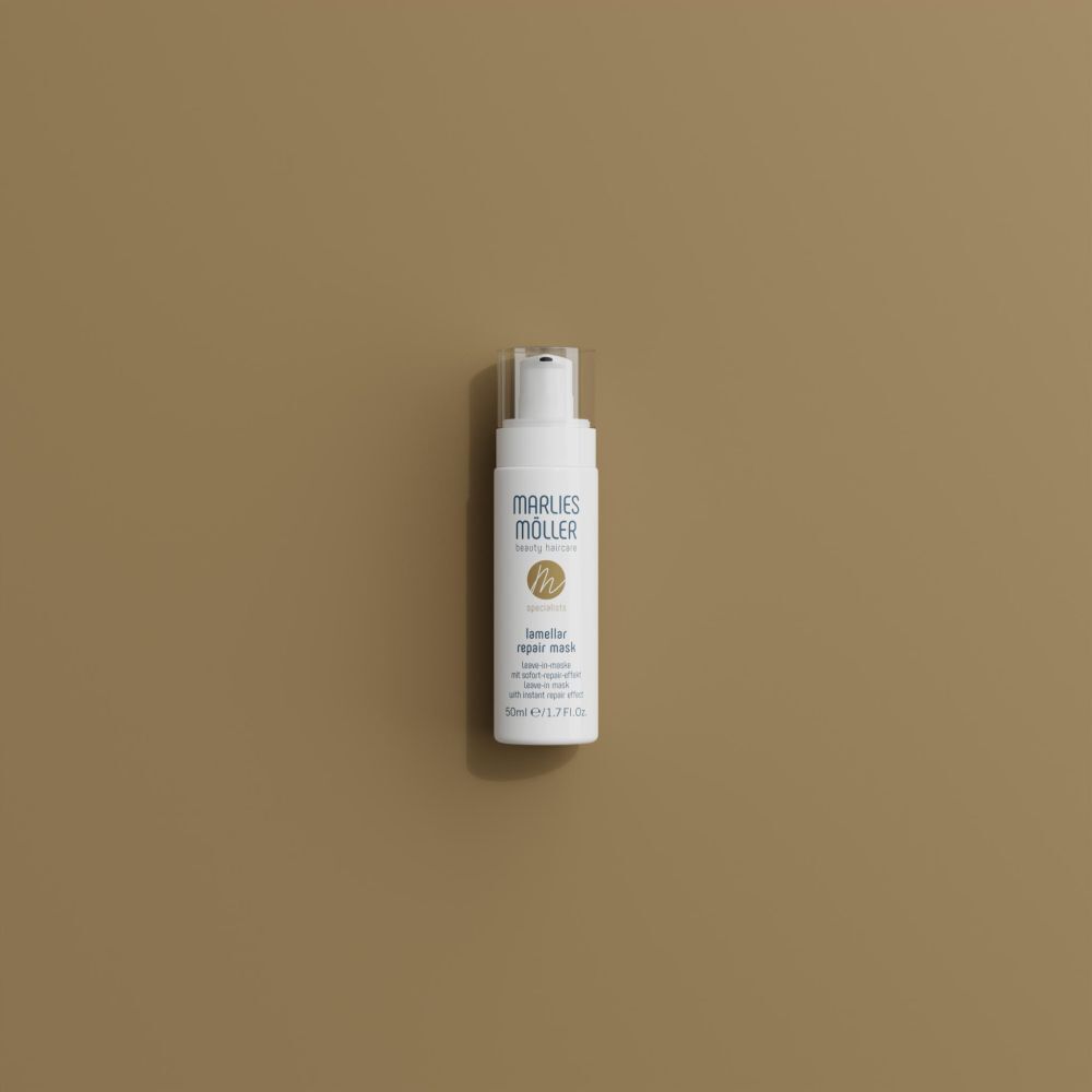 Weiße Flasche mit Pumpverschluss auf braunem Hintergrund. Aufschrift: Marlies Möller, Lamellar Repair Mask. 50ml.
