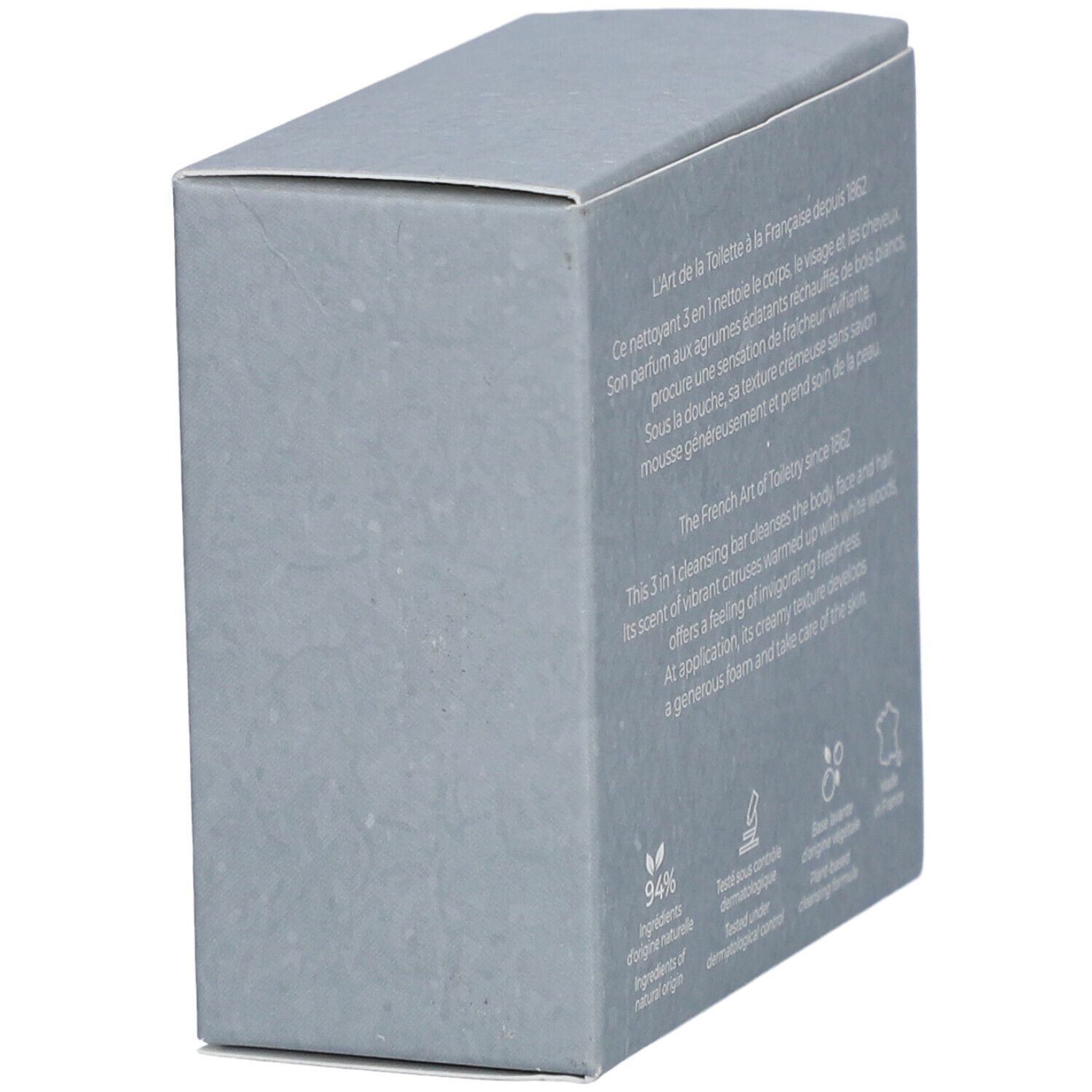 Boîte grise, vue latérale. Texte et logos ingrédients naturels, contrôle dermatologique, base végétale.