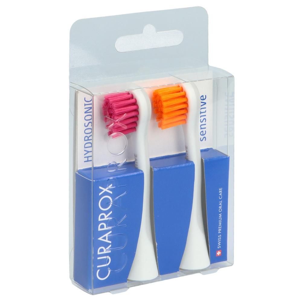 Zwei sensitive Bürstenköpfe in Blisterverpackung. Rosa und orange Borsten. Blaue Verpackung mit CURAPROX-Logo und Schriftzug.