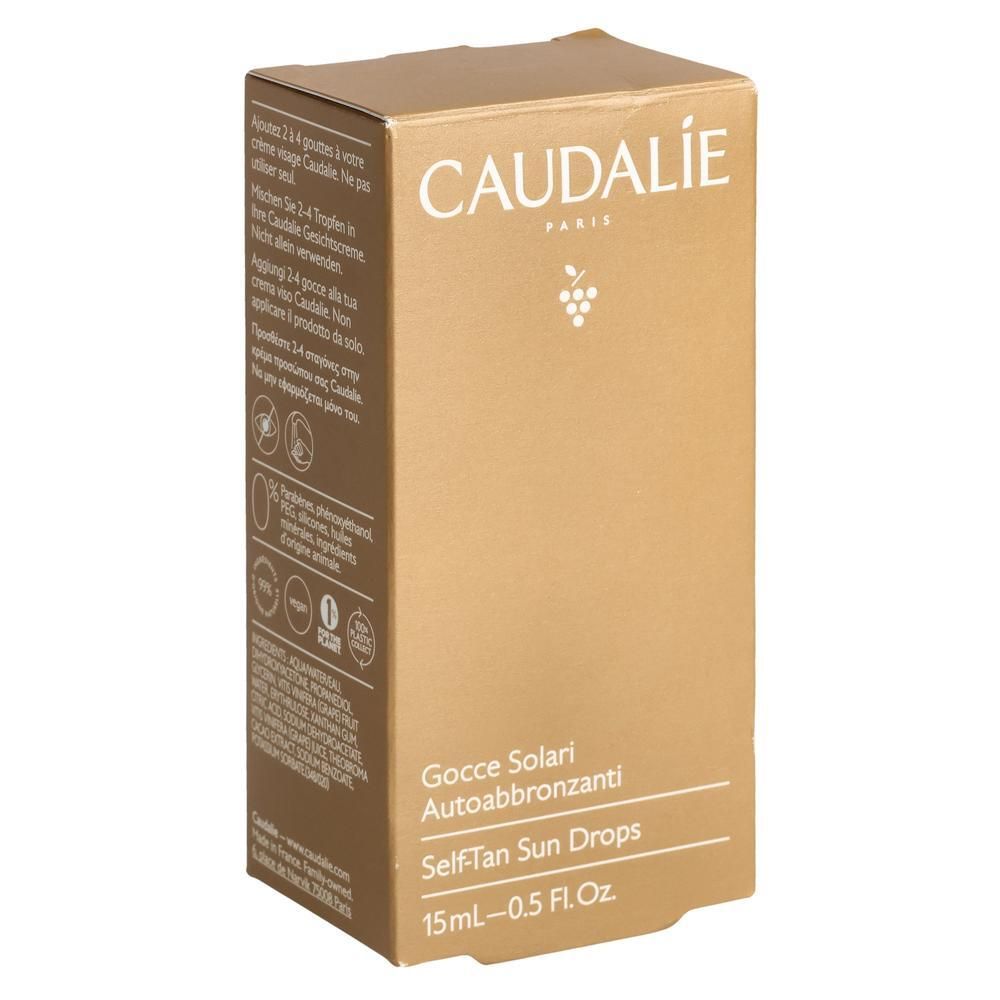 Boîte en carton. Inscription CAUDALIE PARIS, avec un symbole de grappe. En dessous : Gocce Solari Autoabbronzanti, Self-Tan Sun Drops, 15ml-0.5 Fl.Oz.