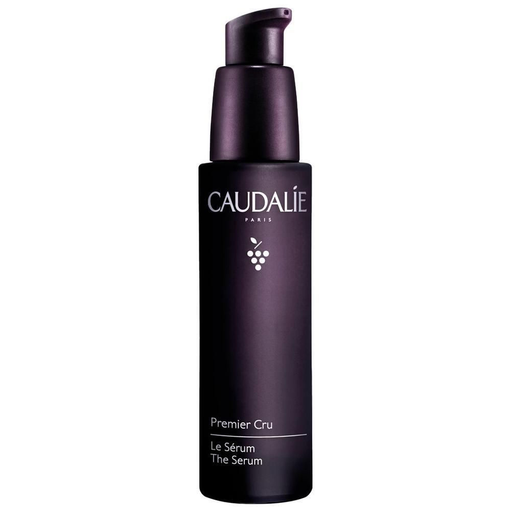 Dunkelviolette Serumflasche mit schwarzem Pumpkopf. Aufschrift CAUDALIE PARIS, darunter Traubensymbol und Produktbezeichnung Premier Cru Le Sérum The Serum.