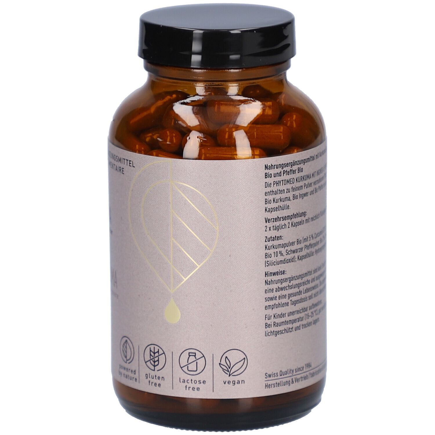 Rückseite der braunen Glasflasche mit schwarzen Deckel. Text auf Etikett. Kurkuma Kapseln mit Ingwer & Pfeffer Bio. Gluten free, lactose free, vegan.