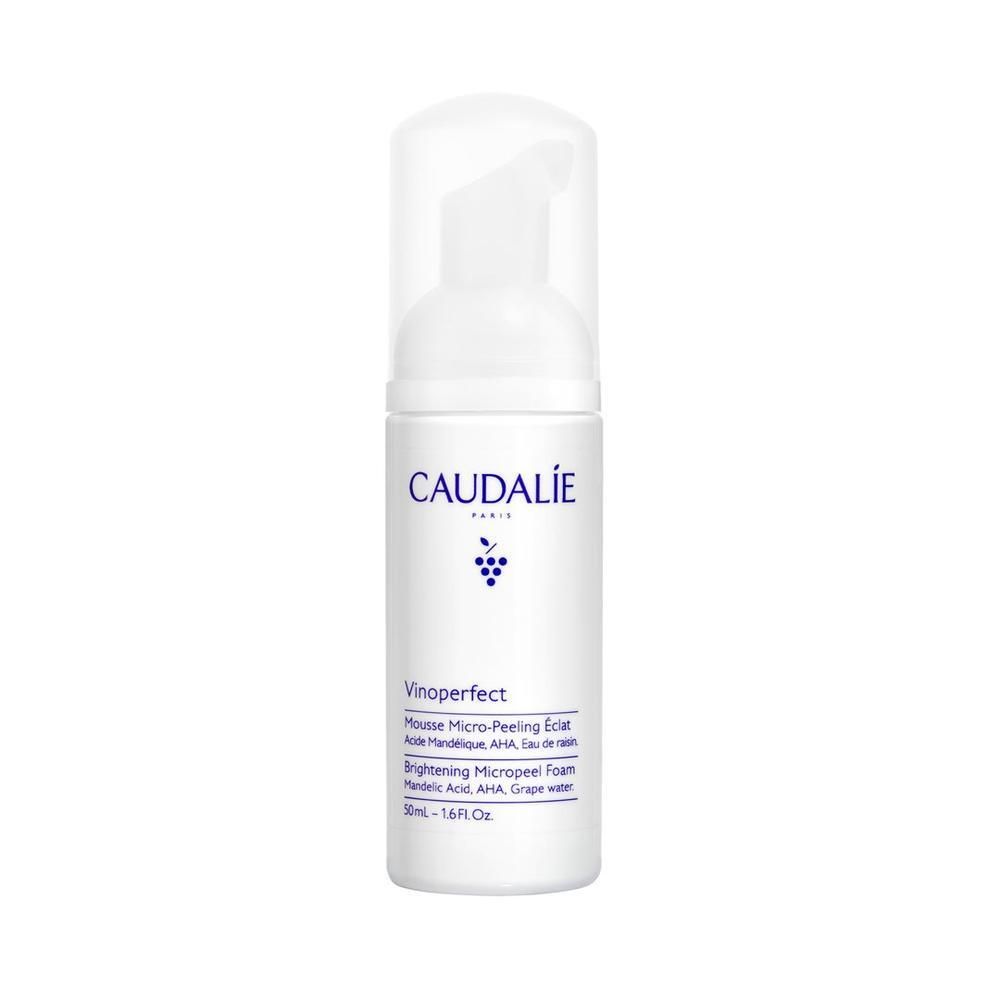 Flacon blanc avec pompe. Inscription: CAUDALIE, Vinoperfect, Mousse Micro-Peeling. Logo de grappe bleu. Texte en français et anglais.