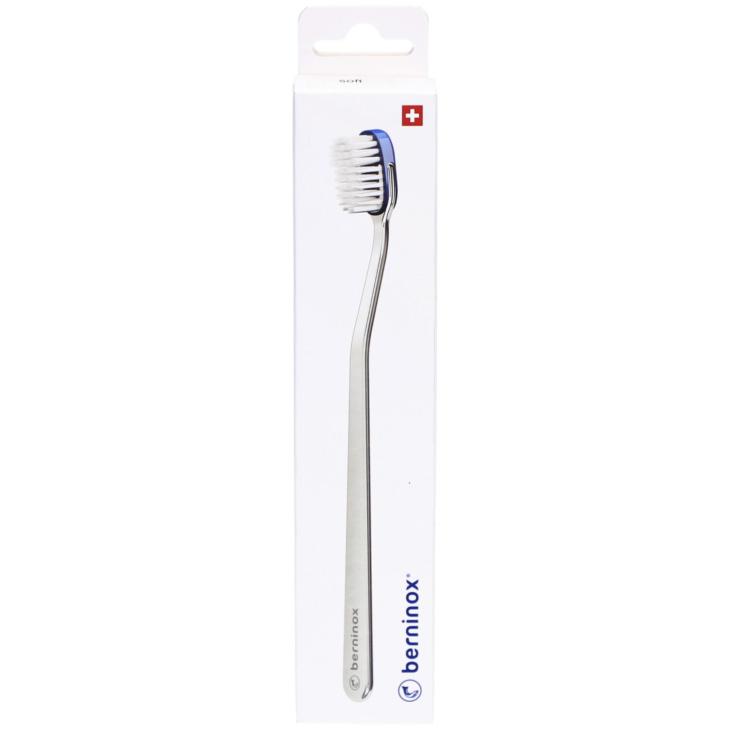 Brosse à dents dans son emballage. Tête blanche, bord bleu, manche argenté. Emballage avec logo et croix suisse.