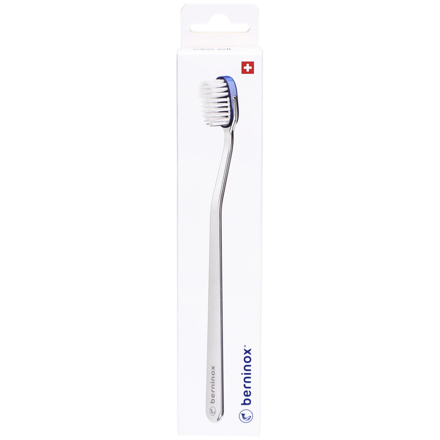Brosse à dents dans son emballage. Boîte blanche avec nom du produit et croix suisse. Brosse à bord bleu.