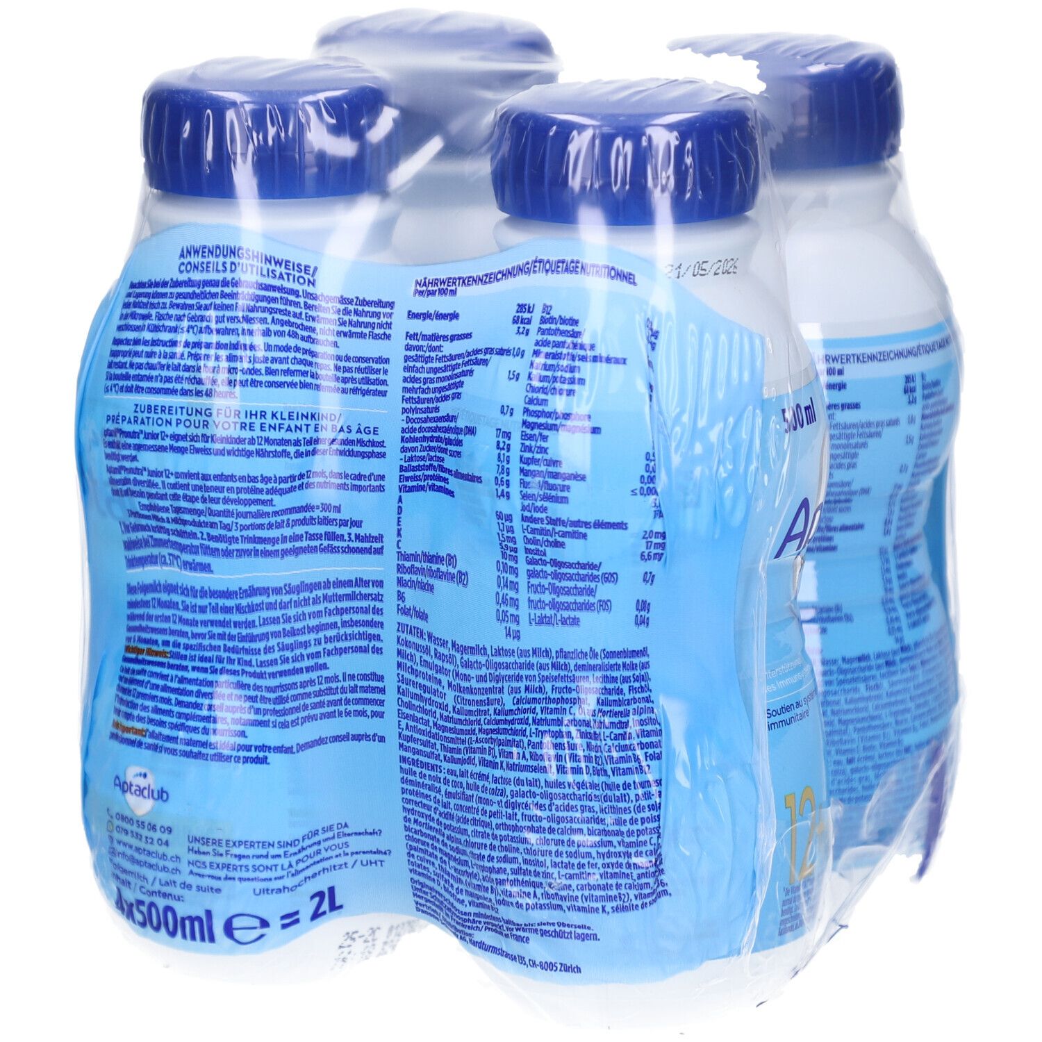 Quatre bouteilles Aptamil Junior emballées. Bouteilles bleues avec bouchons bleus. Inscriptions: Aptamil, Pronutra, 12+.