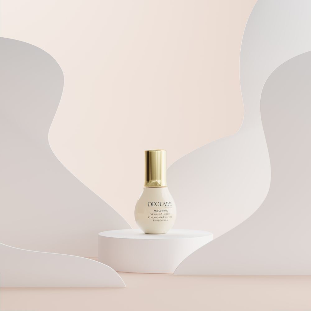 Produit sur socle blanc. Fond avec formes blanches et roses. DECLARÉ Age Control Vitamin A Booster.