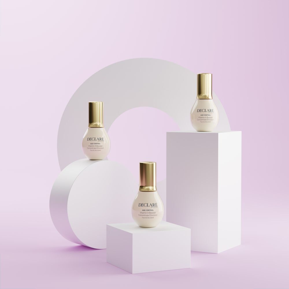Trois flacons sur socles. Fond : cercle et cubes blancs. DECLARÉ Age Control Vitamin A Booster.