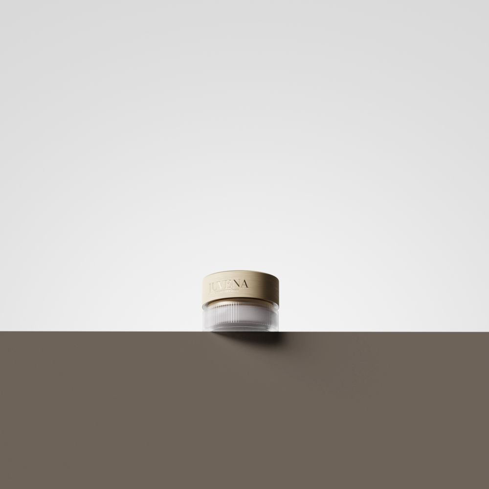 Creme-Tiegel mit goldfarbenem Deckel. Aufschrift: JUVENA. Der Tiegel steht auf einer braunen Oberfläche.