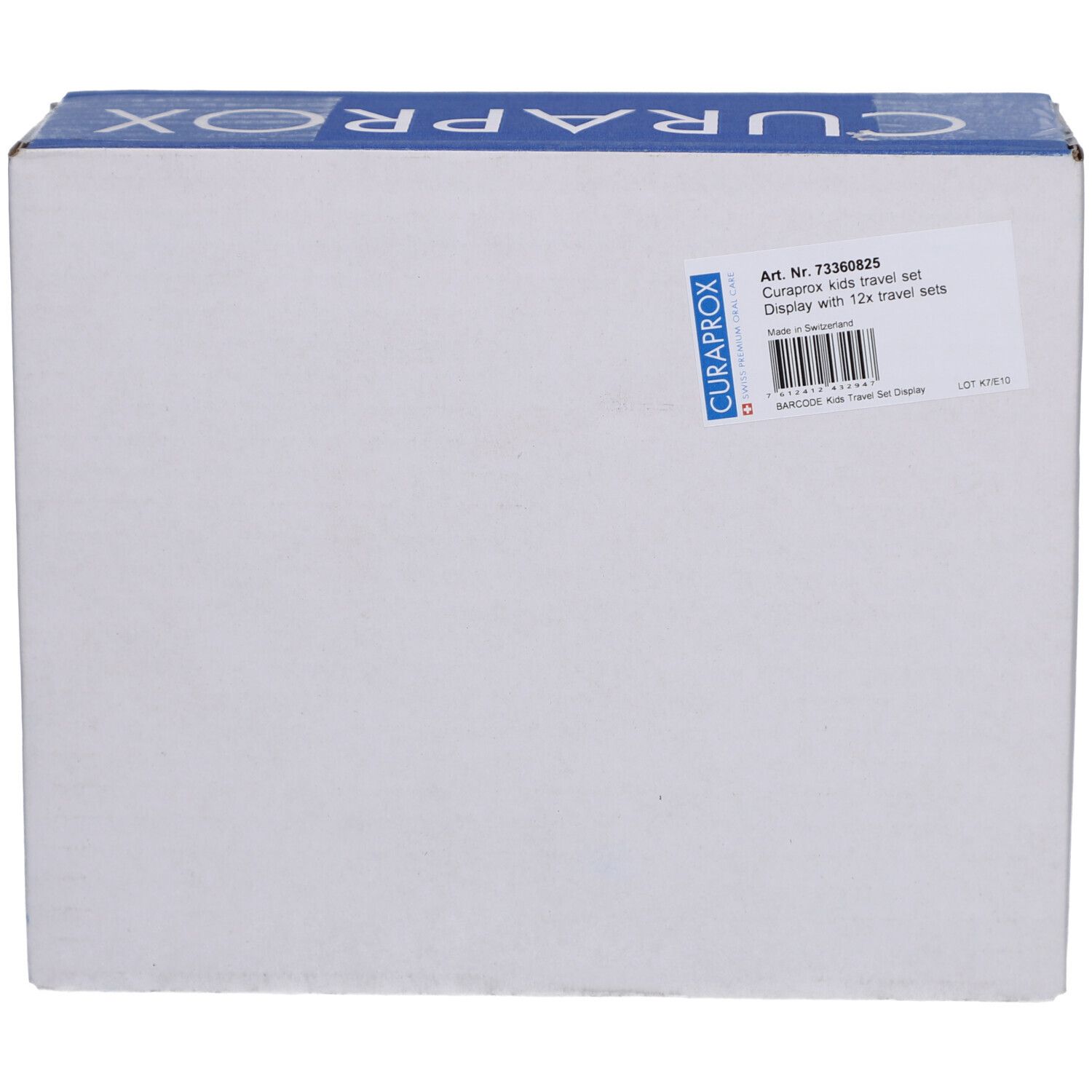 Karton mit CURAPROX-Logo. Aufkleber mit Produktinformationen: CURAPROX Kids Travel Set, Display mit 12 Sets. Artikelnummer und Barcode.
