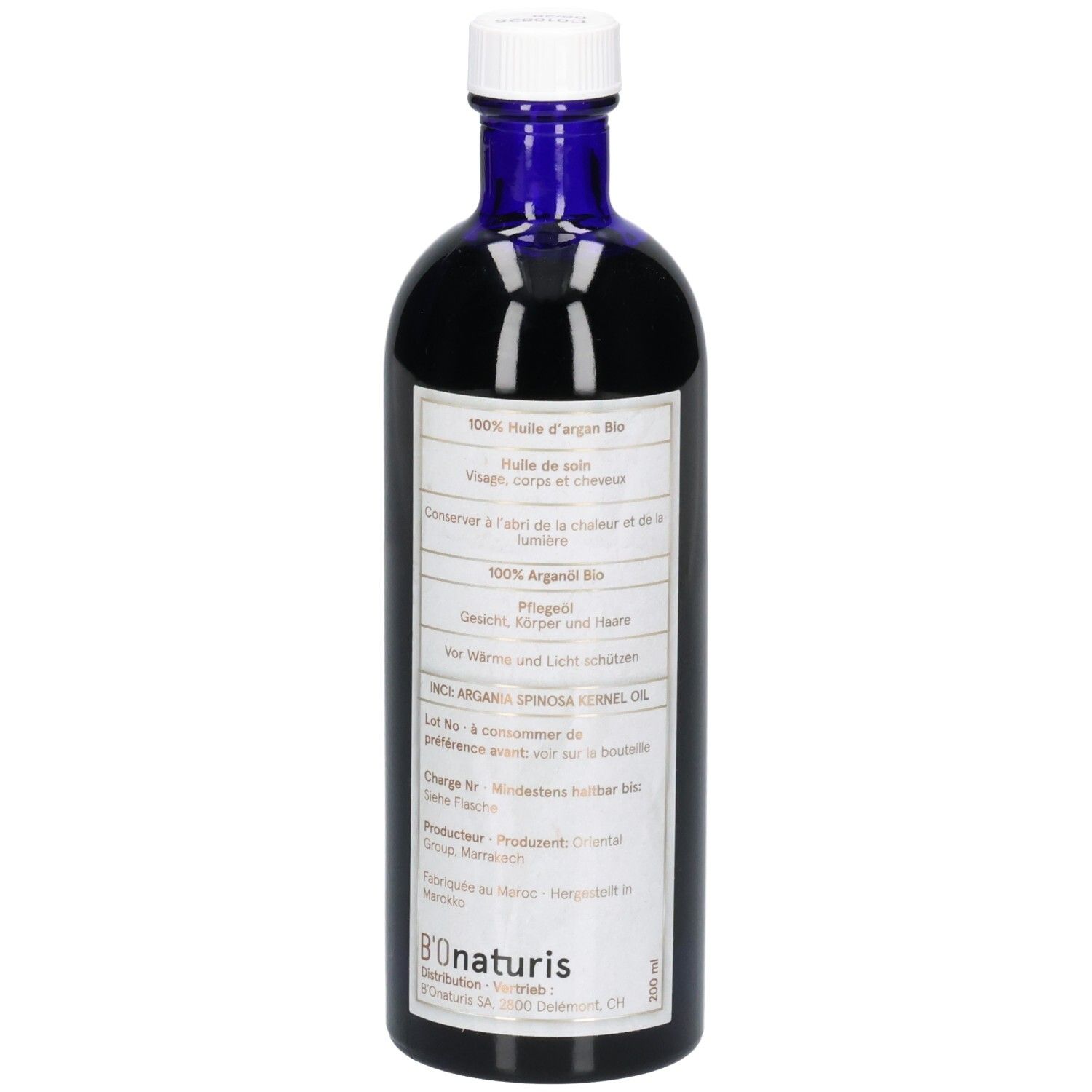 Rückseite einer dunkelblauen Glasflasche mit weißem Verschluss. Etikett mit mehrsprachigen Produktinfos und Logo.
