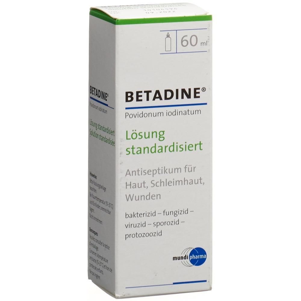 Weiße Schachtel mit grünen Akzenten. Beschriftung: BETADINE, Lösung standardisiert. Enthält 60 ml. Antiseptikum für Haut, Schleimhaut, Wunden.