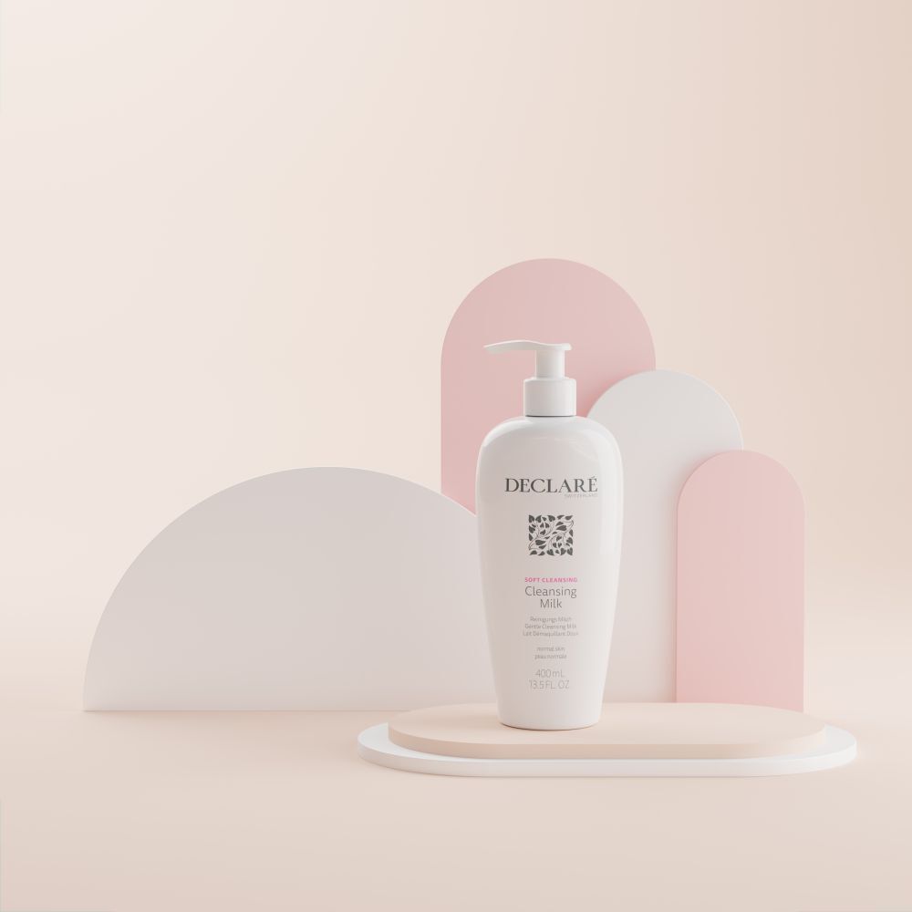 Weiße Flasche mit Pumpe auf Podest. DECLARÉ Cleansing Milk, 400ml. Hintergrund mit Formen.