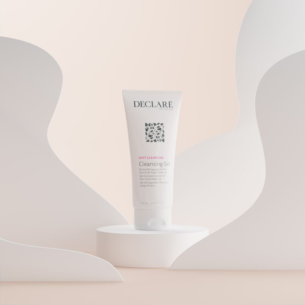 Tube DECLARÉ Cleansing Gel blanc sur socle. Fond : formes abstraites aux tons pastel.