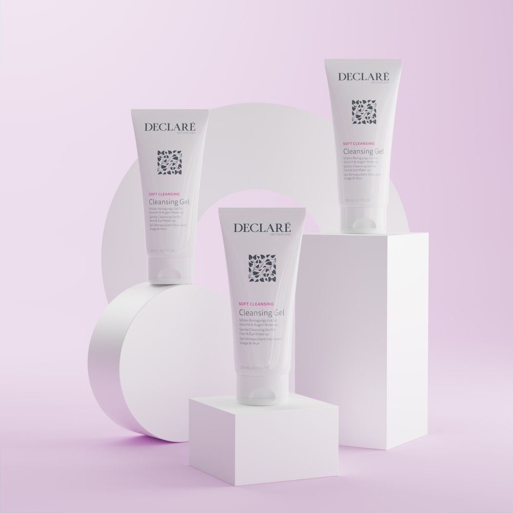 Trois tubes blancs DECLARÉ Cleansing Gel sur socles. Fond : formes géométriques aux tons pastel.