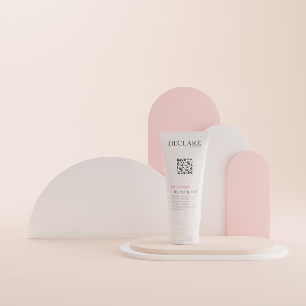 Tube blanc DECLARÉ Cleansing Gel sur socle. Fond : formes géométriques aux tons pastel.