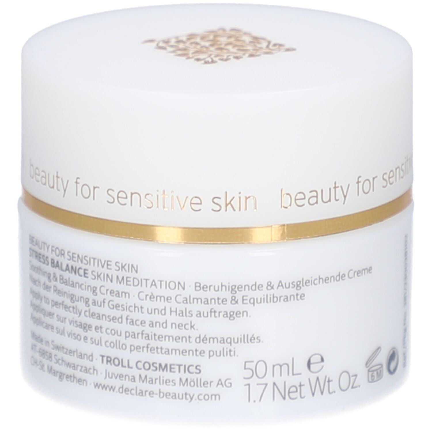 Pot de crème blanc avec bord doré. Inscription : DECLARÉ SWITZERLAND, Skin Meditation Cream. Texte sur le côté.