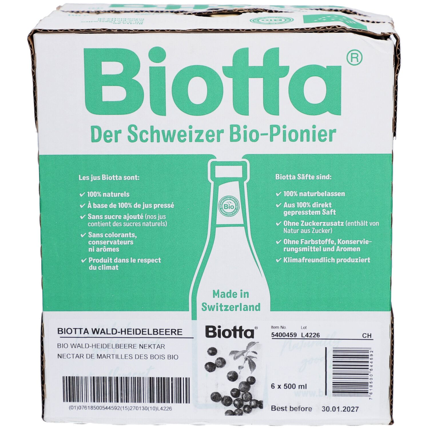 Karton mit BIOTTA Waldheidelbeere Bio. Sechs Flaschen, grüne und weiße Verpackung. Text: Der Schweizer Bio-Pionier. Produktetikett.